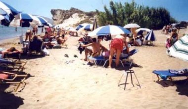 Tourists in Kalamaki engulf a lone sea turtle nest marker (24/07/01).