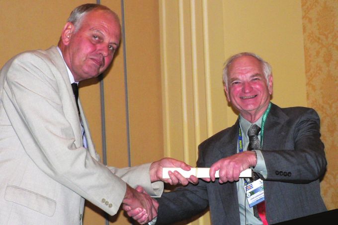 Fig. 4.  Professor John Cooper presents the Elkan Lecturer, Dr John C Harshbarger, with his commemorative certifcate.